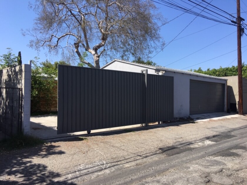 A garage and sliding gate on an alley