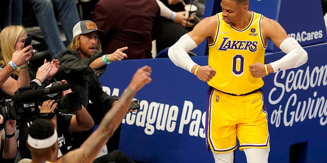 The Los Angeles Lakers' Russell Westbrook celebrates after sinking a basket as fans look on in Dallas Dec. 15, 2021.