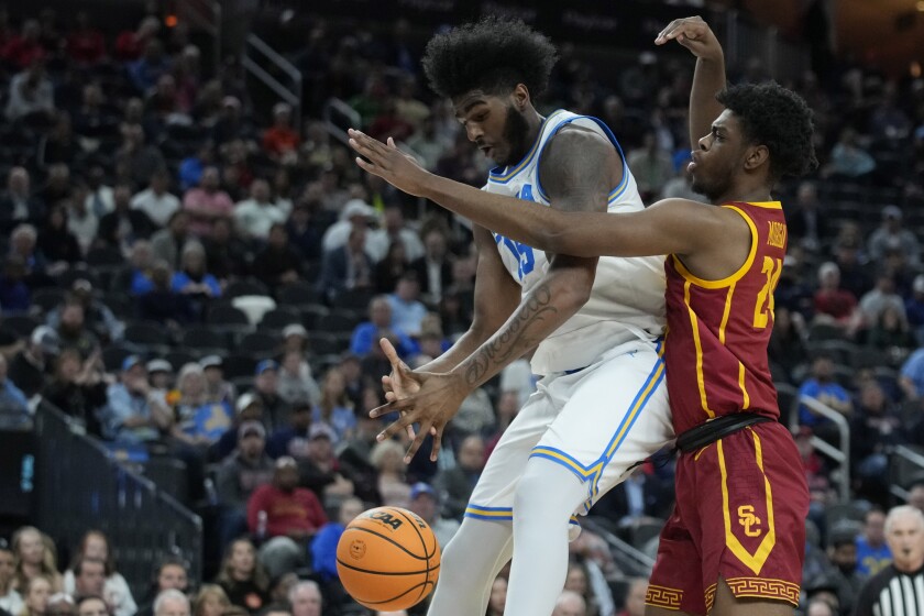 The Trojans' Joshua Morgan, right, defends Bruins big man Myles Johnson during the first half.