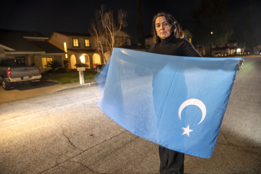 Nurnisa Kurban of Santa Clarita holds a scarf designed as the unofficial flag of Xinjiang