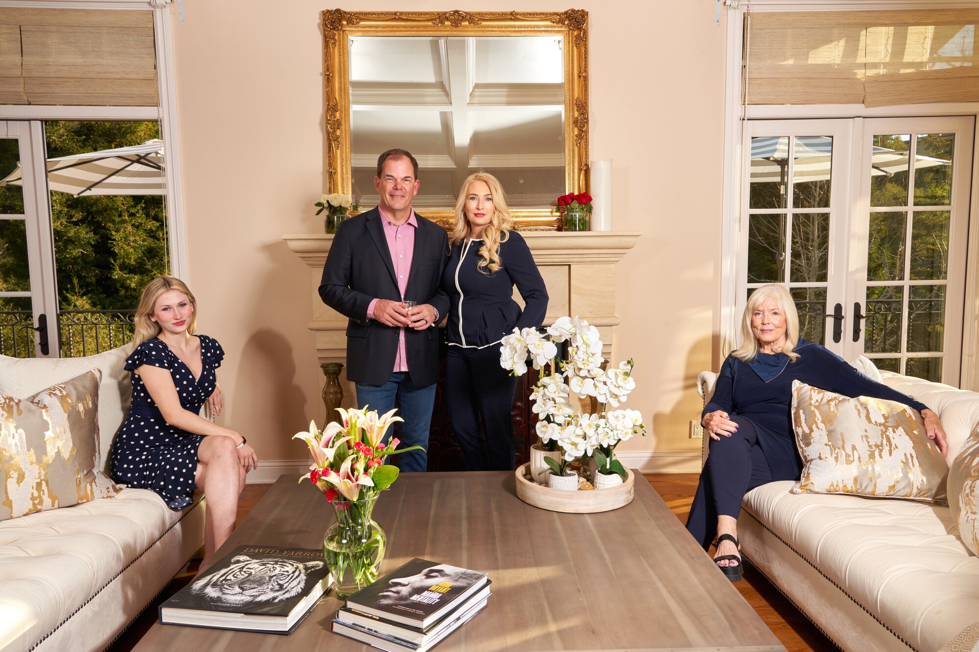 Four people stand for a portrait in a living room.