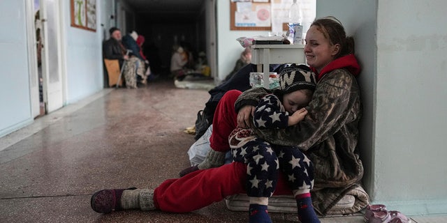 Anastasia Erashova cries as she hugs her child in a corridor of a hospital in Mariupol, eastern Ukraine on Friday, March 11, 2022. Anastasia's other child was killed during the shelling of Mariupol. (AP Photo/Evgeniy Maloletka)