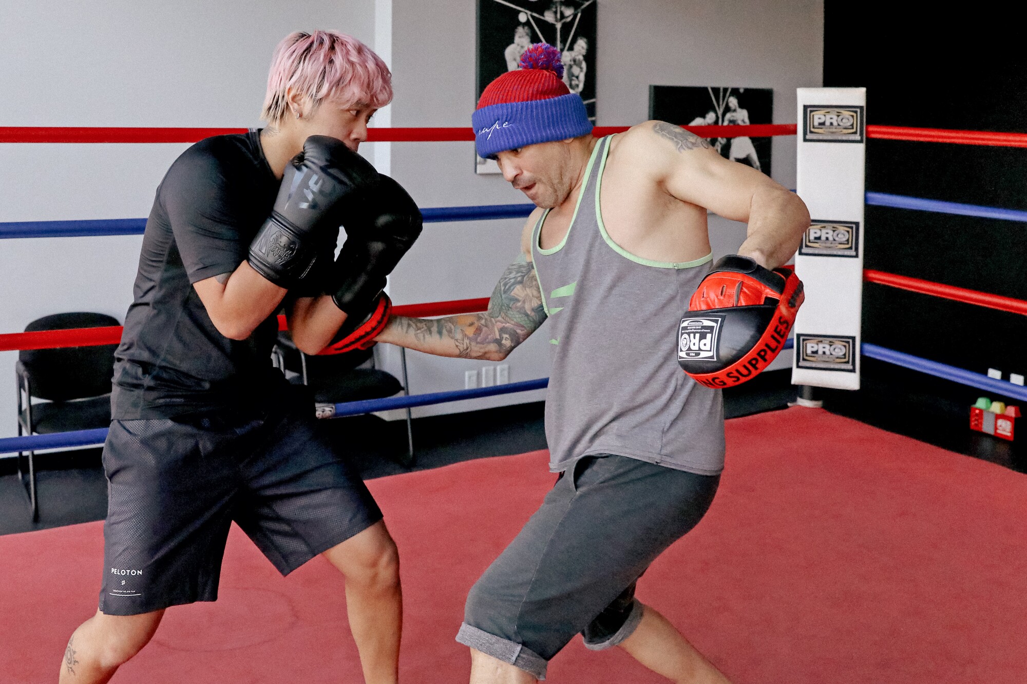 A boxer, left, works in the ring with his trainer