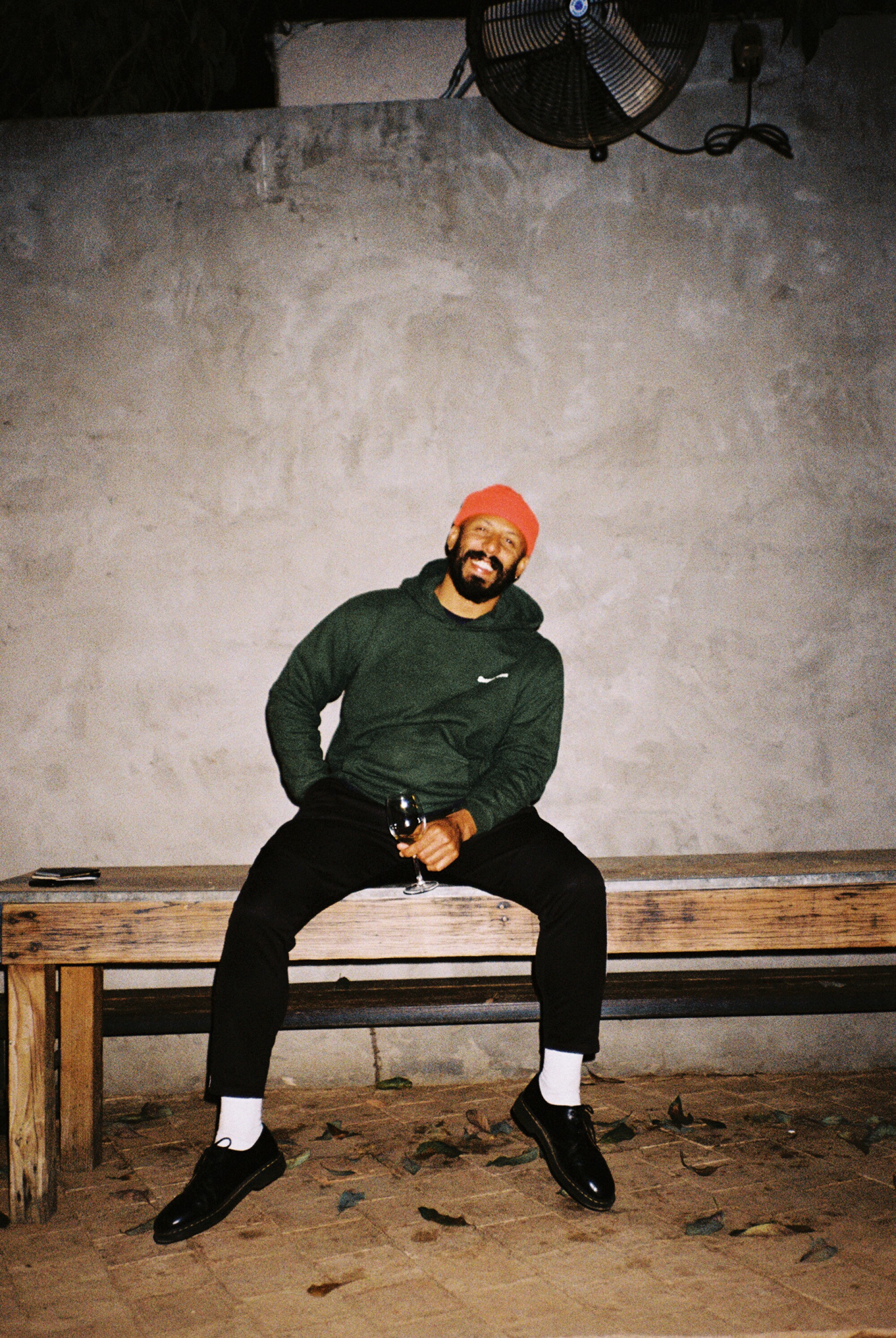 A smiling man in an orange cap and white socks.
