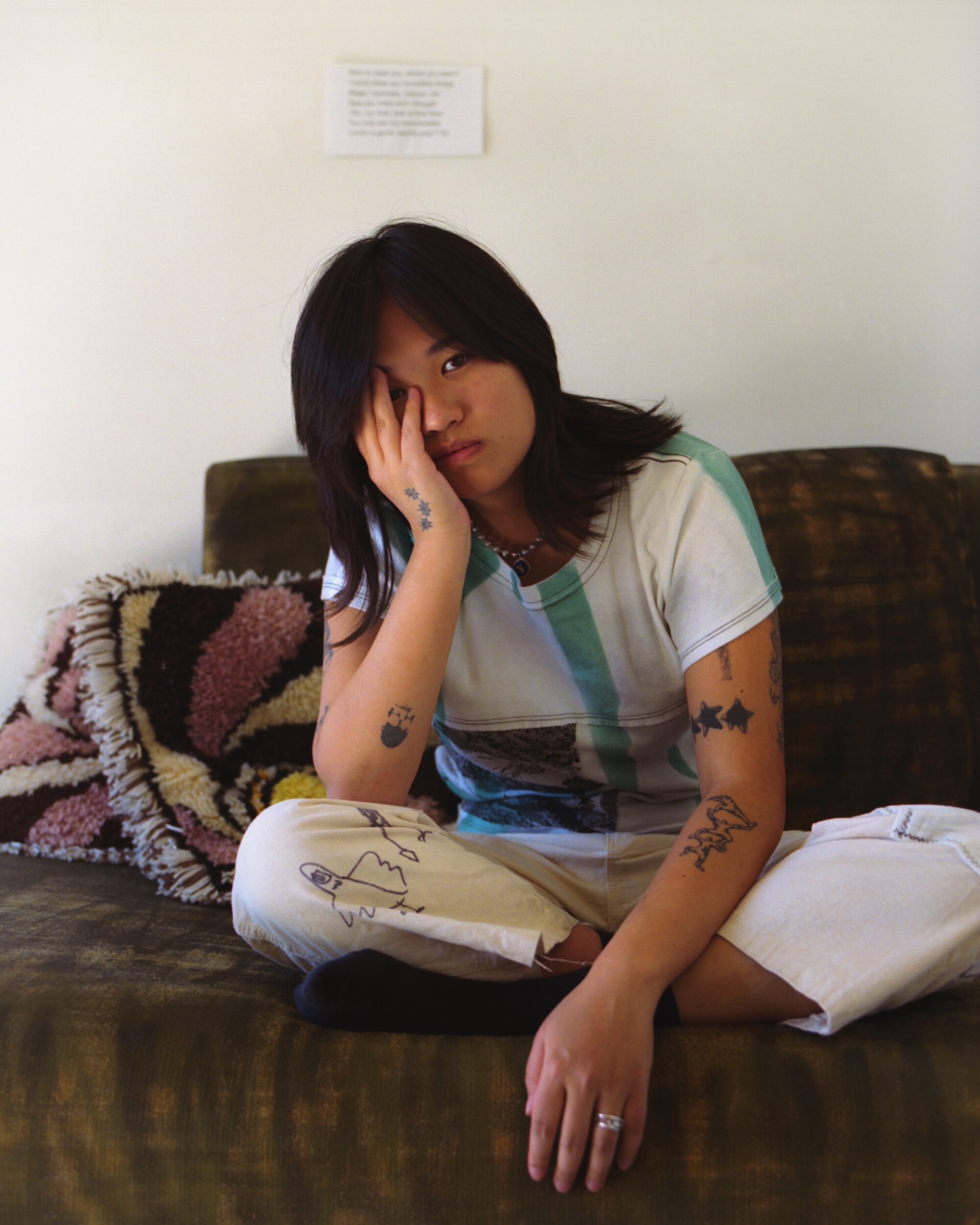 A woman sits with her head resting on her hand.