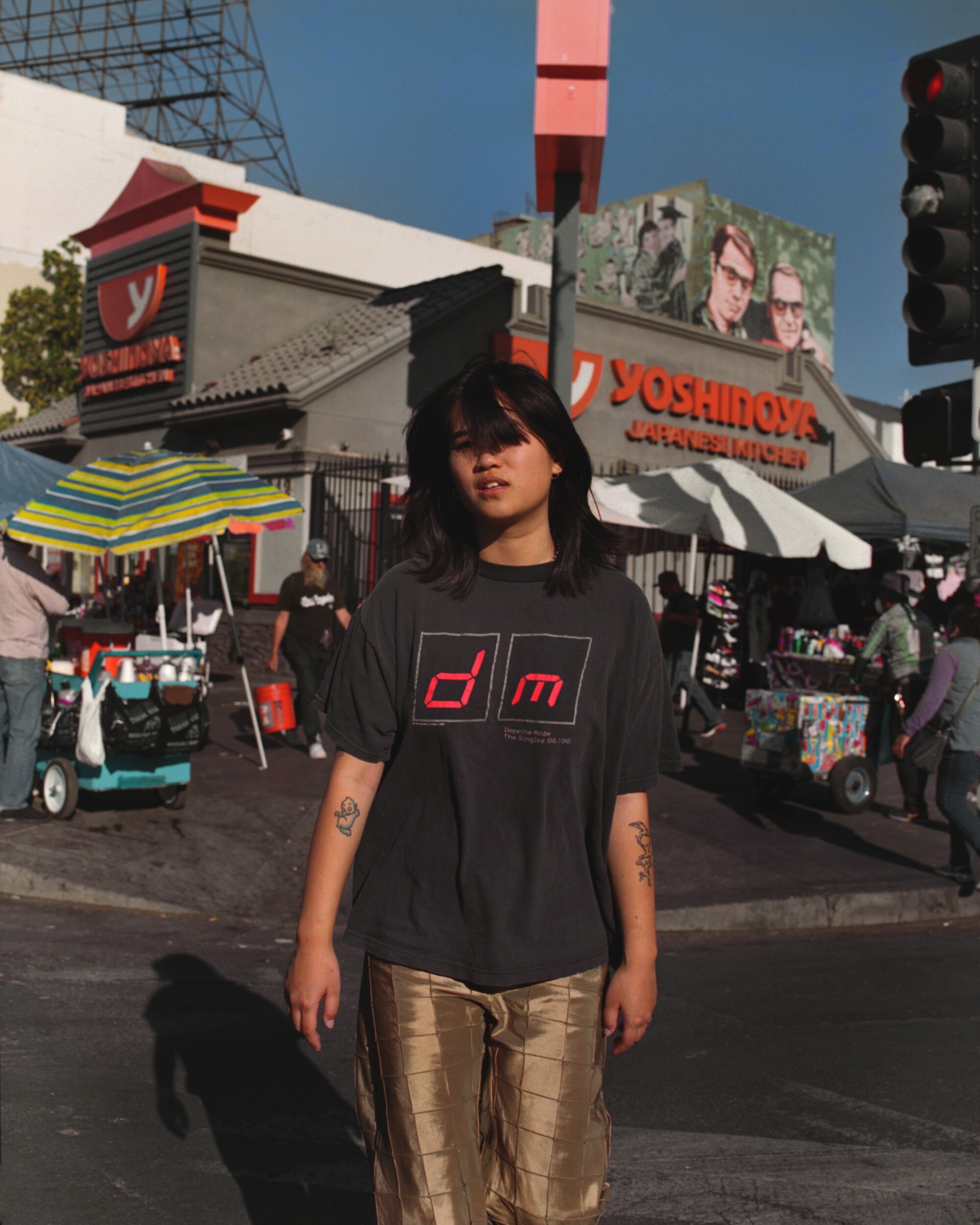 A woman stands in front of a restaurant.