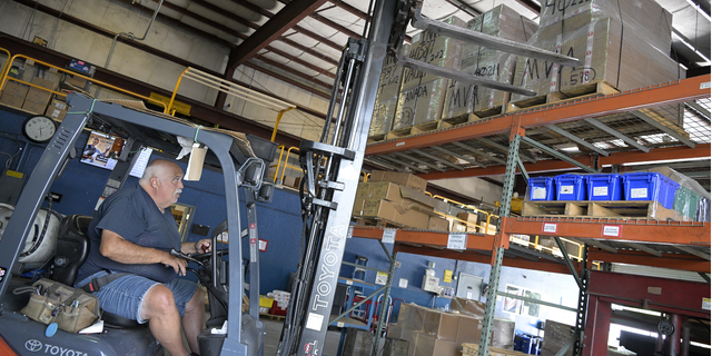 Employee John Marra moves pallets containing a shipment of 9mm SUB2000 rifles awaiting shipment to Ukraine at the KelTec gun manufacturing facility on Thursday.