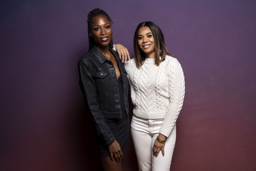 A woman wearing denim, left, and a woman wearing all white pose for a picture 