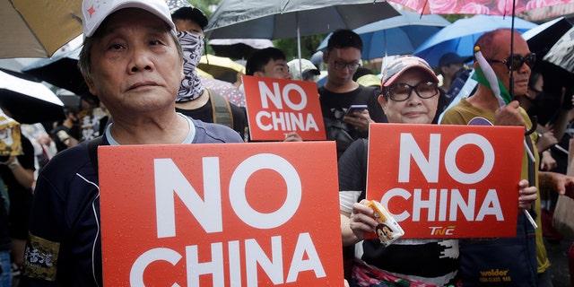 Hong Kong students and Taiwanese supporters hold slogans during a march in Taipei, Taiwan, Sunday, Sept. 29, 2019. Sunday's demonstration was part of global "anti-totalitarianism" rallies planned in over 60 cities worldwide, including in Australia and Taiwan, to denounce "Chinese tyranny." (AP Photo/Chiang Ying-ying)
