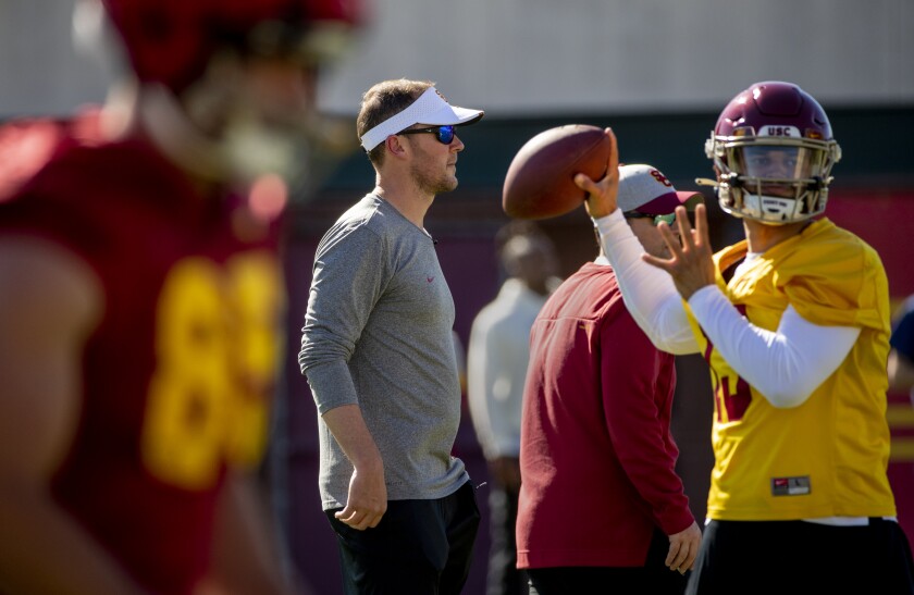 USC coach Lincoln Riley looks on as quarterback Caleb Williams makes a pass.