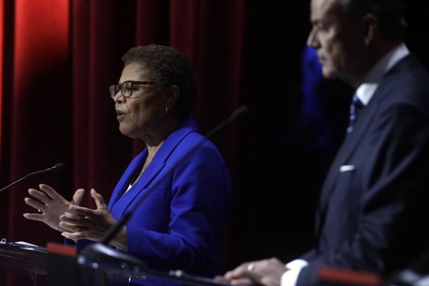 Rep. Karen Bass speaks as Rick Caruso listens.