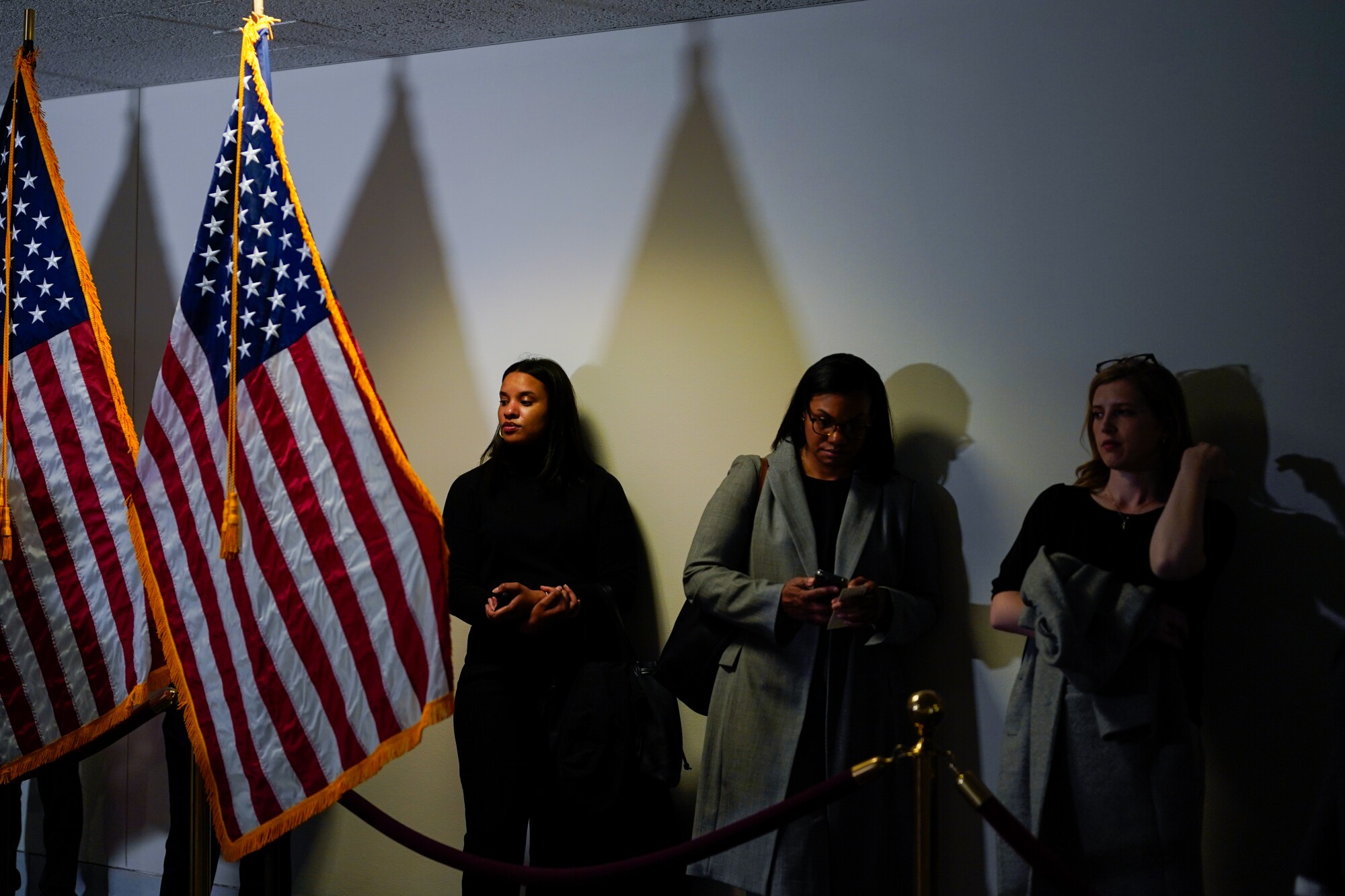 People line up near a roped-off area. 