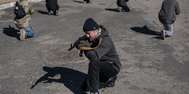 Civilians practice moving in groups at a military training exercise