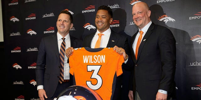 Denver Broncos new starting quarterback Russell Wilson, center, is flanked by head coach Nathaniel Hackett, right, and general manager George Paton after a news conference Wednesday, March 16, 2022, at the team's headquarters in Englewood, Colo. 