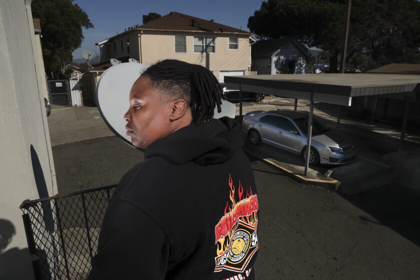 A woman wears a dark hoodie sweatshirt with flames printed on the back.