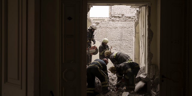 Emergency workers search for bodies under the debris of the regional administration building, heavily damaged after a Russian attack earlier this month in Kharkiv, Ukraine, Sunday, March 27, 2022. 