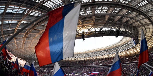 People wave Russian flags during a concert marking the eighth anniversary of Russia's annexation of Crimea at Luzhniki Stadium in Moscow March 18, 2022. 