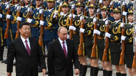 Russian President Vladimir Putin (C) reviews a military honour guard with Chinese leader Xi Jinping (L) in Beijing on June 8, 2018. 