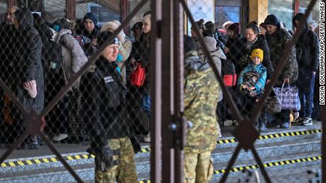 People line up Monday after arriving from Ukraine at the train station in Przemysl, near the Ukrainian-Polish border.