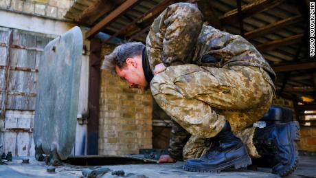 A Ukrainian soldier peeks inside a captured Russian armored personnel carrier that has been painted in Ukrainian colors.