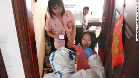 A medical worker takes a swab sample from a resident for nucleic acid test at a community of Jiutai District in Changchun, northeast China&#39;s Jilin Province on March 18, 2022. 