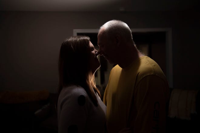 Tracy and Chris Etheridge hold each other in their living room in Waverly, Tenn., Thursday, March 10, 2022. The two recently married after Chris Etheridge saved Tracy from drowning in floodwaters in the flood that hit Waverly six months ago.”In the middle of the flood, we thought we were going to die,” Tracy Etheridge said, “And I remember he kissed me on the forehead.” 