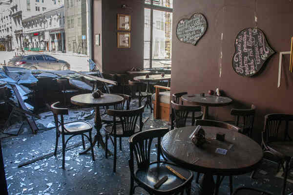 A stylish cafe with broken windows and debris.