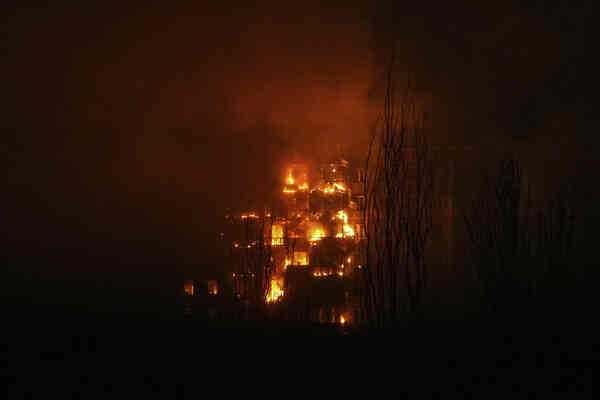 A building-shaped fire burning at night.