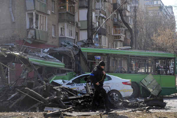 A green bus and white taxi, both with major damage.