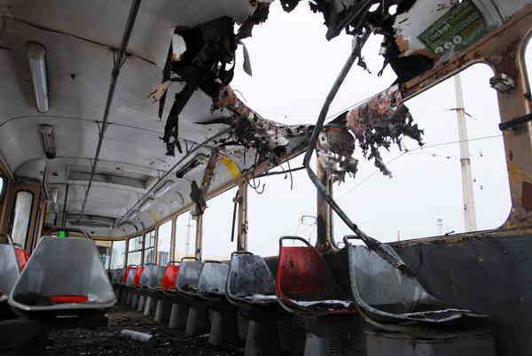 The interior of a bus with a blasted hole in the roof.