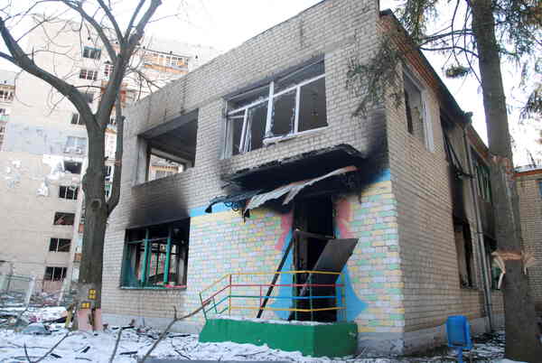 A burnt out rectangular building with colorful markings.