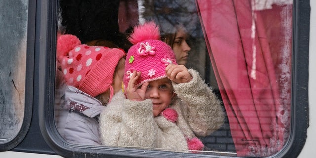 A Ukrainian girl sits in a vehicle with other children arranged by Aerial Recovery.