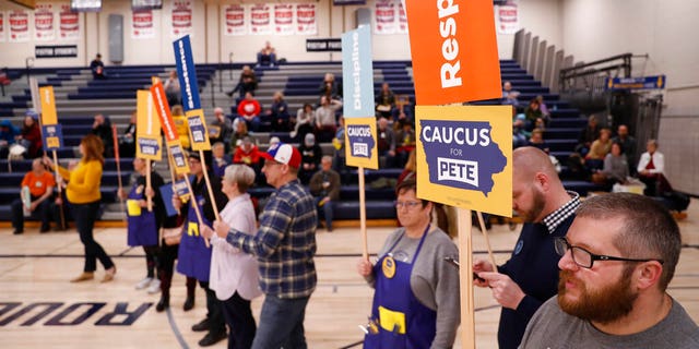 Supporters of Democratic presidential candidate former South Bend, Indiana, Mayor Pete Buttigieg stand at a caucus site at Roosevelt Hight School, Monday, Feb. 3, 2020, in Des Moines, Iowa. 