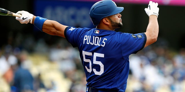 Los Angeles Dodgers' Albert Pujols follows through after hitting a solo home run against the New York Mets during the first inning of a baseball game in Los Angeles, Saturday, Aug. 21, 2021.
