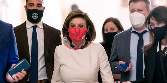 Speaker of the House Nancy Pelosi, D-Calif., walks with reporters seeking updates about a vote on President Joe Biden's $1.85 trillion domestic policy package, as well as a companion $1 trillion infrastructure bill, at the Capitol in Washington Nov. 4, 2021.