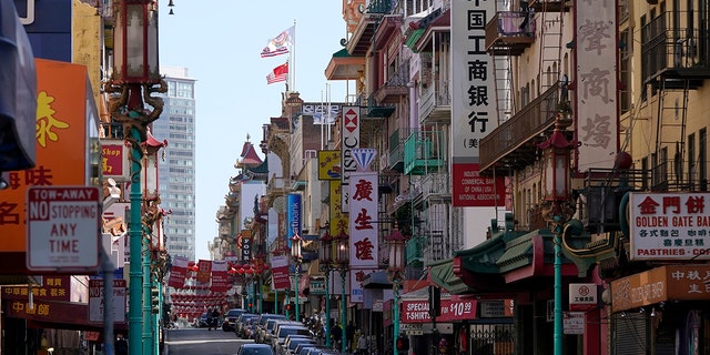 FILE - A person crosses Grant Avenue in Chinatown in San Francisco, Thursday, March 25, 2021. By unanimous vote the San Francisco Board of Supervisors on Tuesday, Feb.1, 2022 approved a resolution apologizing to Chinese immigrants and their descendants on behalf of the board and the city for its racist past. (AP Photo/Jeff Chiu, File)