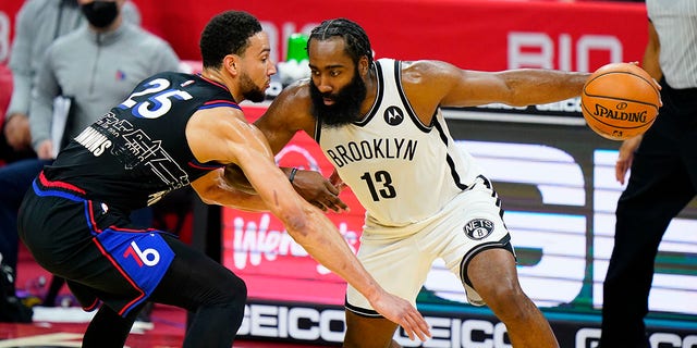 The Brooklyn Nets' James Harden (13) tries to drive past the Philadelphia 76ers' Ben Simmons (25) Feb. 6, 2021, in Philadelphia. 