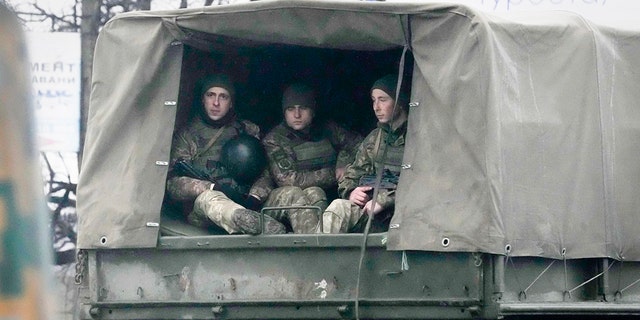 Ukrainian soldiers ride in a military vehicle in Mariupol, Ukraine, Thursday, Feb. 24, 2022. (AP Photo/Sergei Grits)