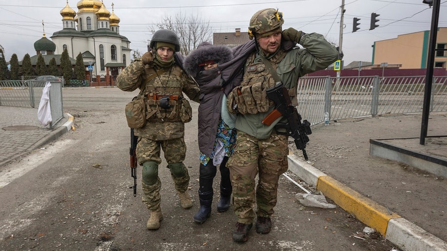 Ukrainian servicemen help elderly woman in Irpin, Ukraine