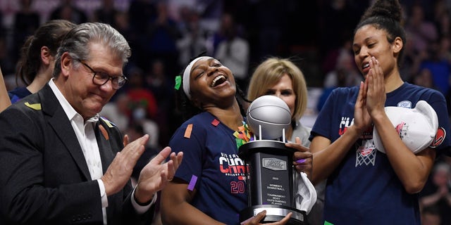 Connecticut's Christyn Williams, center, reacts after receiving the tournament's most outstanding player award. 