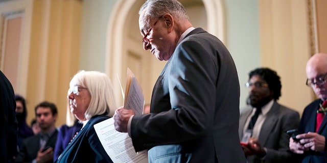 Senate Majority Leader Chuck Schumer, D-N.Y., looks over his notes before taking questions from reporters and speaking about the Russian invasion of Ukraine, at the Capitol in Washington, Tuesday, March 8, 2022.