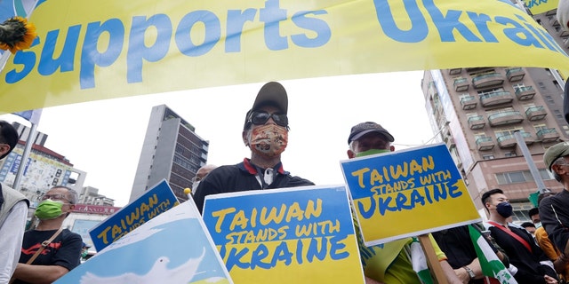 Ukrainian people in Taiwan and supporters hold posters to protest against the invasion of Russia in solidarity with the Ukrainian people during a march in Taipei, Taiwan, Sunday, March 13, 2022. (AP Photo/Chiang Ying-ying)