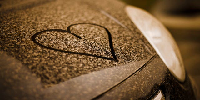 A drawn heart is seen on a black painted car covered with sahara dust, in Zurich, Switzerland.