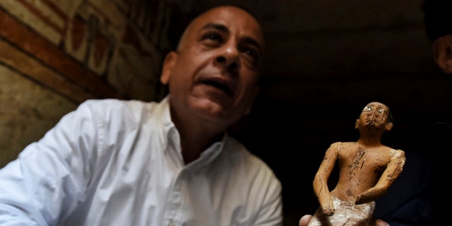 Mostafa Waziri, Secretary General of the Supreme Council of Antiquities, displays a statue found in a recently discovered tomb near the famed Step Pyramid, in Saqqara, south of Cairo, Egypt, Saturday, March 19, 2022.