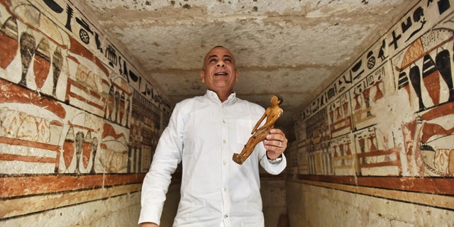 Mostafa Waziri, Secretary General of the Supreme Council of Antiquities, displays a small statue at a tomb decorated with hieroglyphic inscriptions at a recently discovered tomb near the famed Step Pyramid, in Saqqara, south of Cairo, Egypt, Saturday, March 19, 2022.