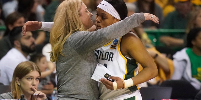 Baylor guard Sarah Andrews, right, gets a hug from head coach Nicki Collen after Andrews fouled out in the final minutes of the second half of a college basketball game against South Dakota in the second round of the NCAA tournament in Waco, Texas, Sunday, March 20, 2022.