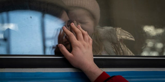 Displaced Ukrainians on a Poland-bound train bid farewell in Lviv, western Ukraine, Tuesday, March 22, 2022. The U.N. refugee agency says more than 3.5 million people have fled Ukraine since Russia's invasion, passing another milestone in an exodus that has led to Europe's worst refugee crisis since World War II. 