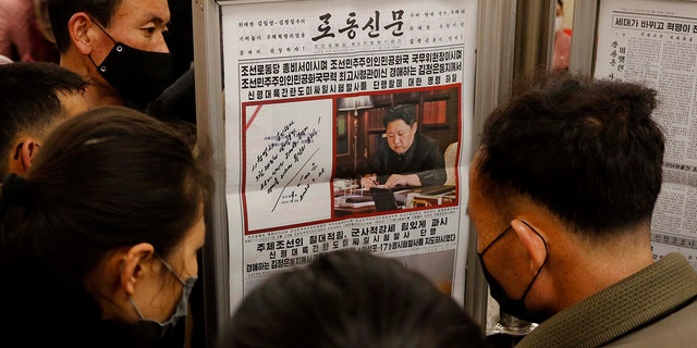 People look at a copy of North Korea' newspaper Rodong Sinmun showing the report about the test-launch of a missile, at the Jonsung Station of Pyongyang Metro in Pyongyang, North Korea, on March 25, 2022. 