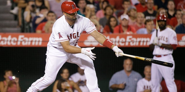 Los Angeles Angels star Albert Pujols hits a three-run double during the third inning of a baseball game against the Seattle Mariners Monday, Sept. 15, 2014, in Anaheim, Calif.