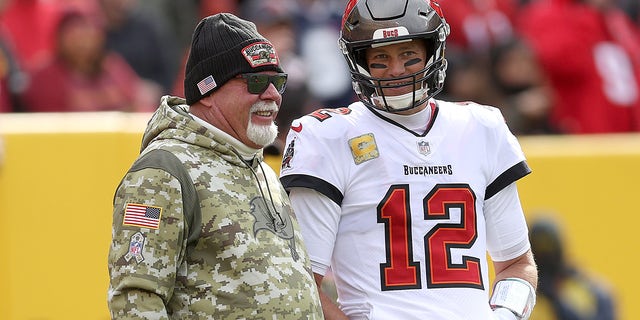 Head coach Bruce Arians of the Tampa Bay Buccaneers talks with quarterback Tom Brady during a game against the Washington Football Team at FedEx Field Nov. 14, 2021, in Landover, Md.